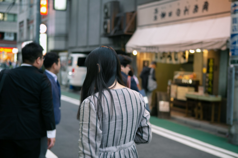 まちをあるくてらおさんのうしろすがたのしゃしん。