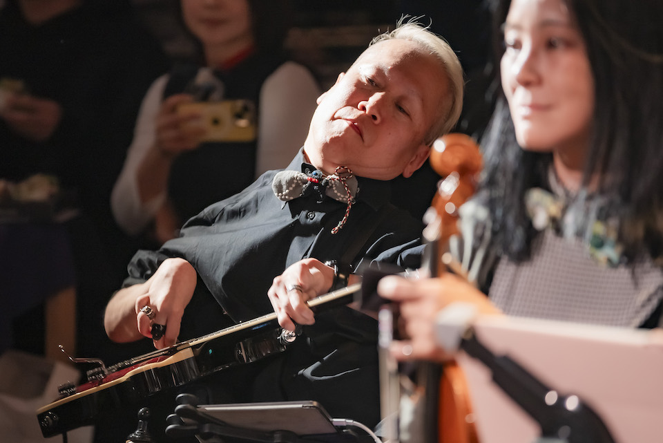 【写真】黒いシャツに身を包みエレキギターを演奏する川崎昭仁さん